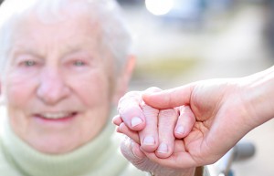 Senior Lady and Young Woman Holding Hands